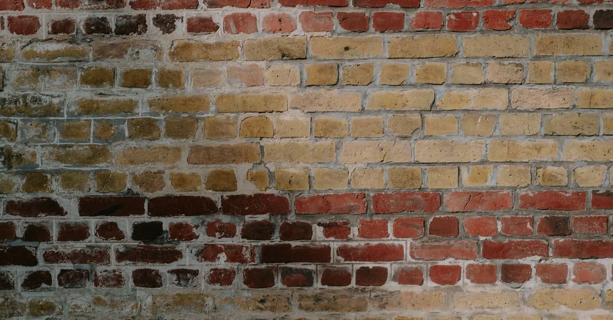 Vue détaillée d'un mur en briques rouges et jaunes rustiques, mettant en valeur une texture vieillie.